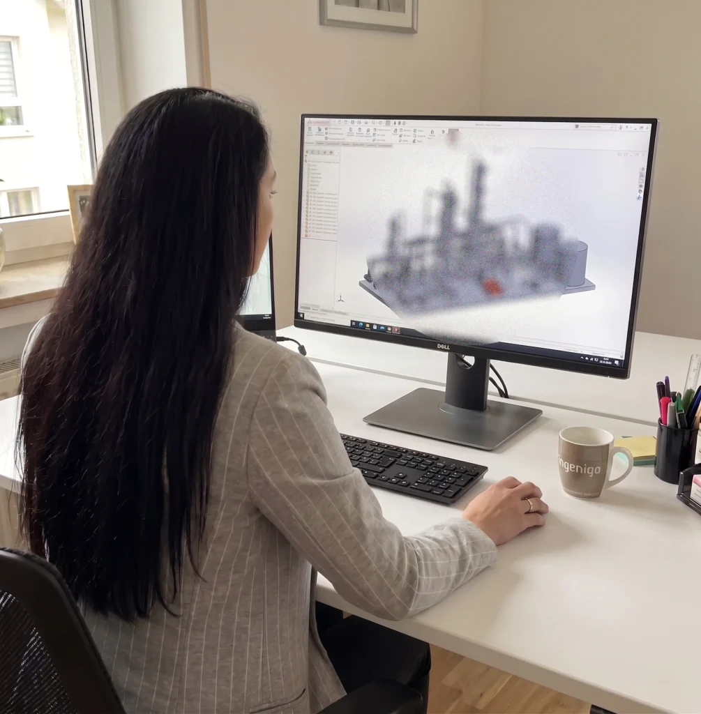 Anika sitzt am CAD-Rechner und schaut sich eine Industrieanlage im SolidWorks an.